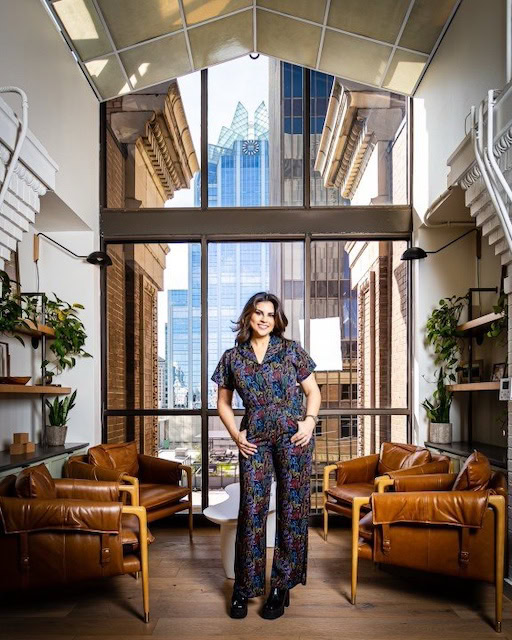 CEO of Disrupt PR stands infront of a window.
