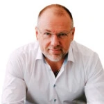 A man with glasses, Dental Practitioner Gary L. Cash, D.D.S., in a white shirt against a white background, symbolizes Austin PR consulting and social media management expertise.