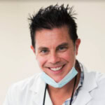 Dr. Gary L. Cash smiles in a white coat, embodying professional management; an example of Austin's Public Relations expertise.