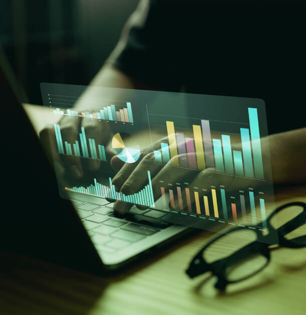 A person types on a laptop with charts, symbolizing Public Relations analytics in Austin; glasses and consulting materials are nearby.