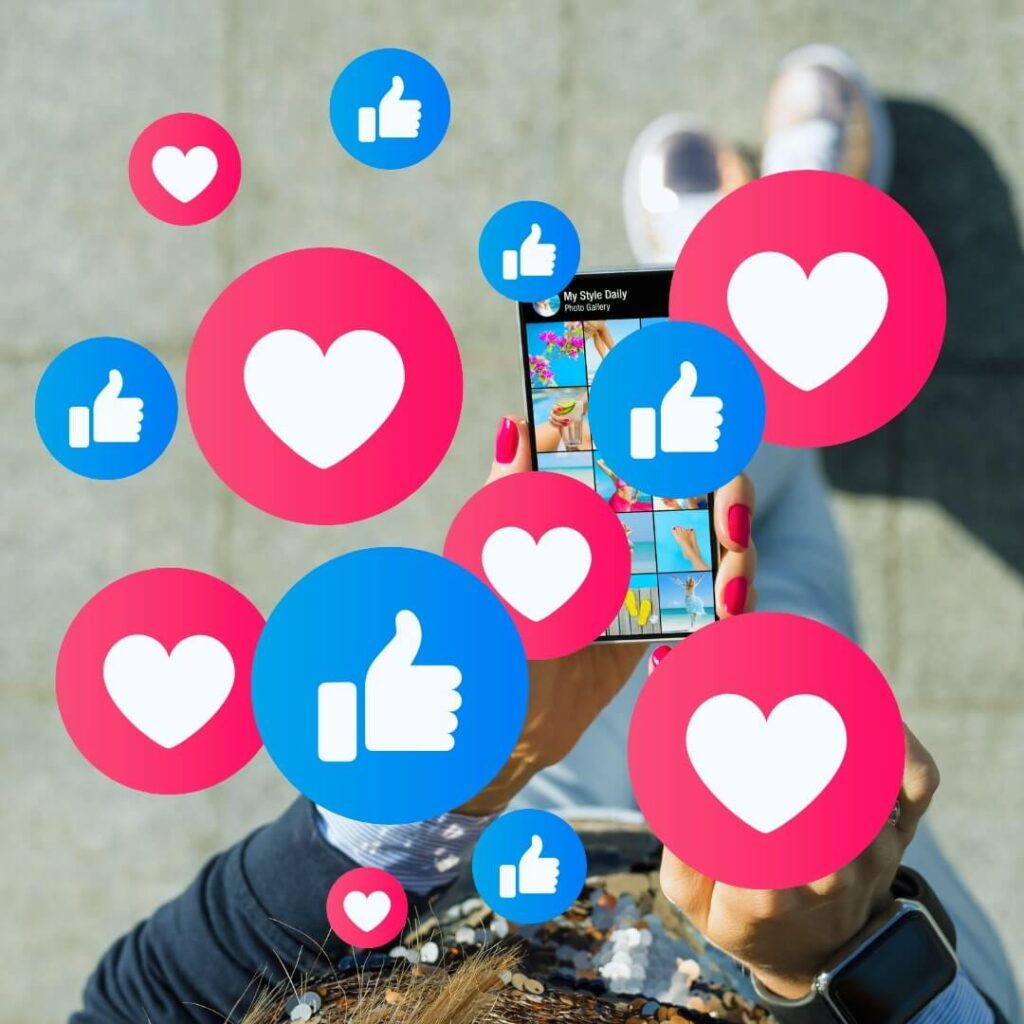 A person holds a smartphone showing a photo gallery with heart and thumbs-up icons, symbolizing Austin PR agency's social media management impact.