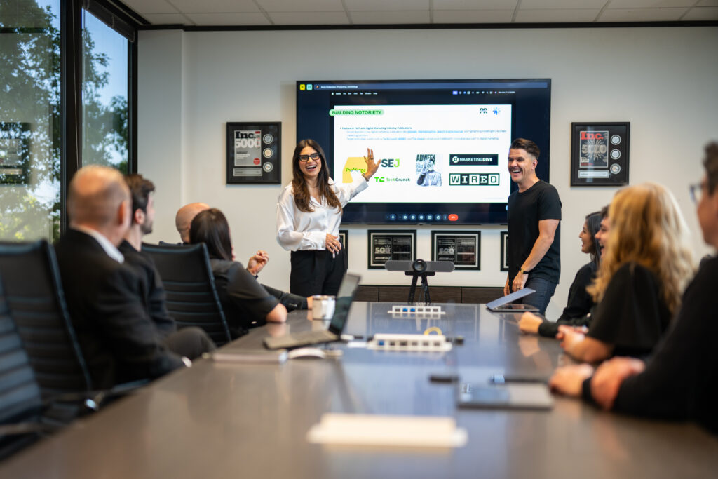 Presenters in a conference room discuss Email Forwarders, Austin Public Relations, Social Media, and Crisis Management strategies.